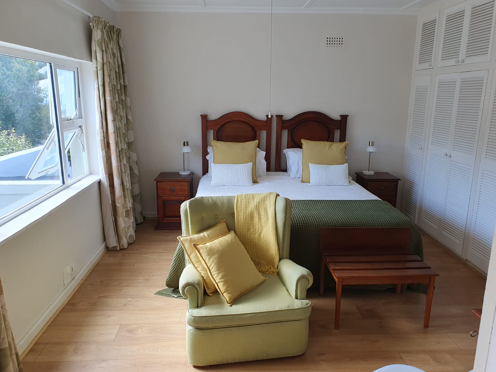 Hibiscus Suite bedroom with king bed, armchair and large window