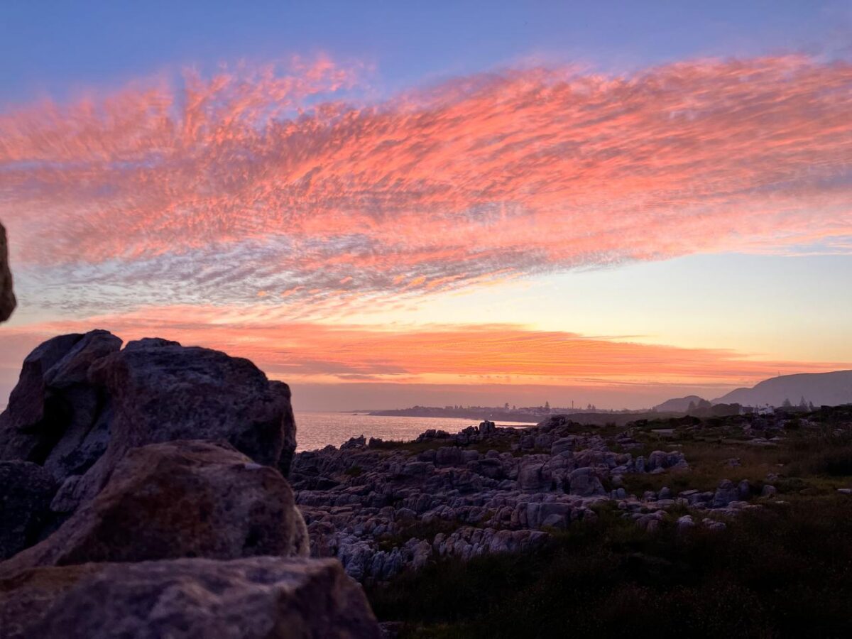 Pink sunset sky over the rocks of the Hermanus coastline