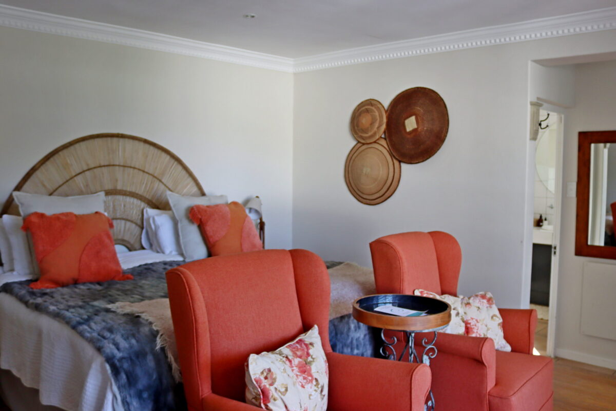 Mountain Suite bedroom with king bed and coral armchairs